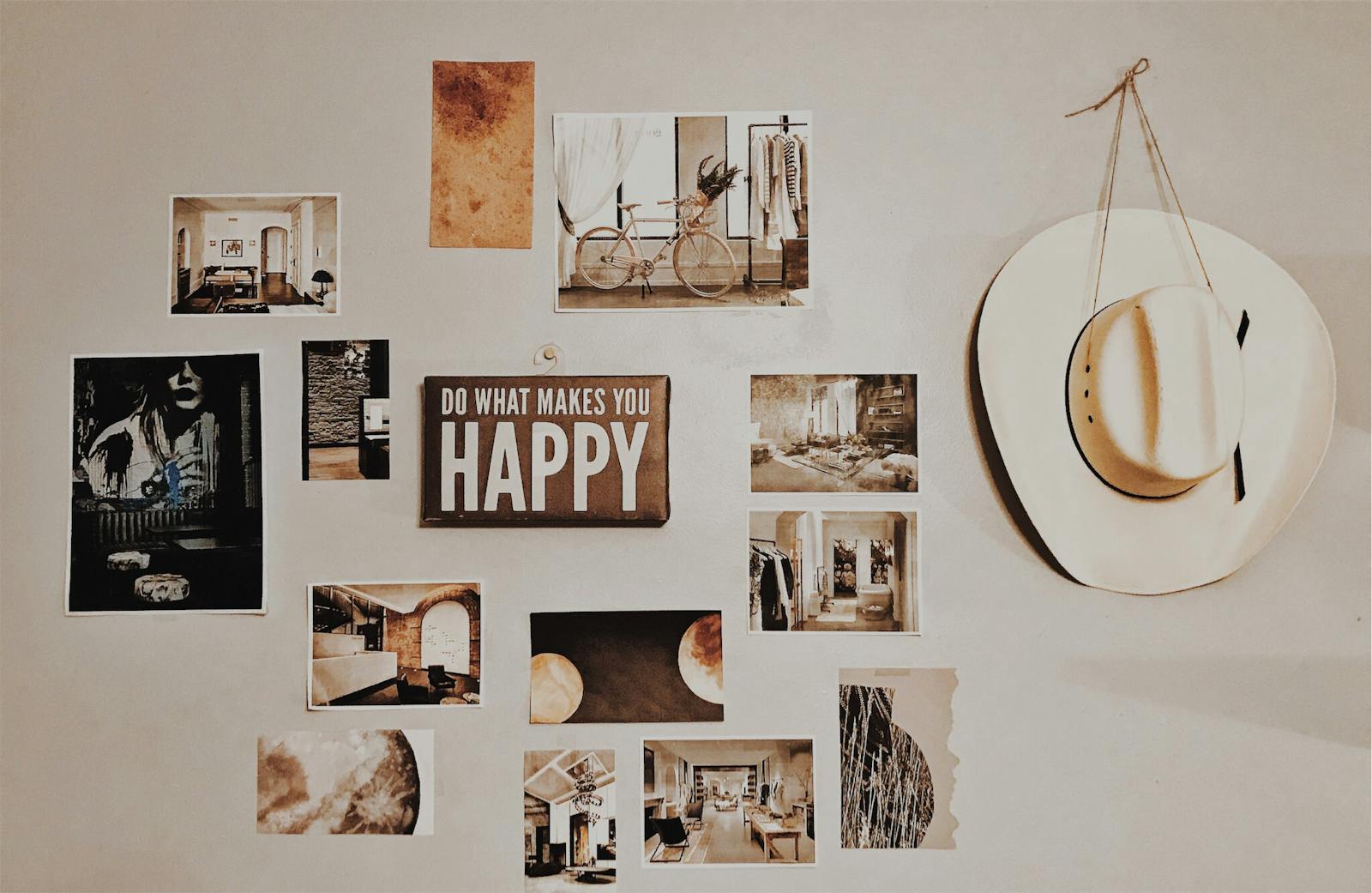 Gallery wall with photos, art, and an inspirational sign, featuring a cowboy hat.