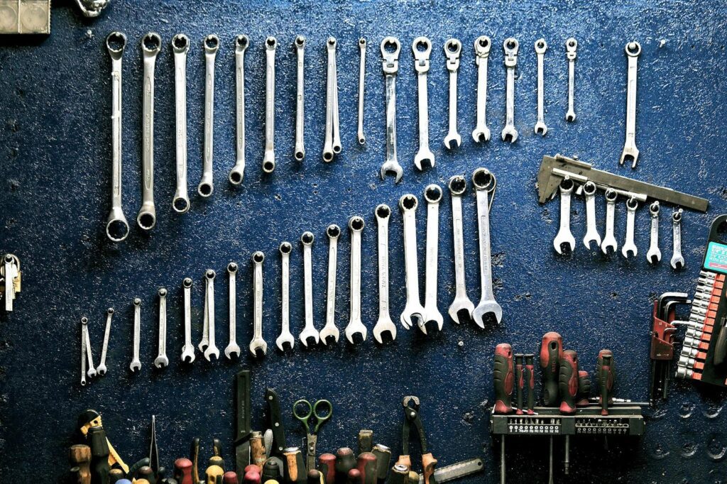 Photo by Pixabay Neatly arranged wrenches and tools on a workshop wall, ideal for mechanics.
