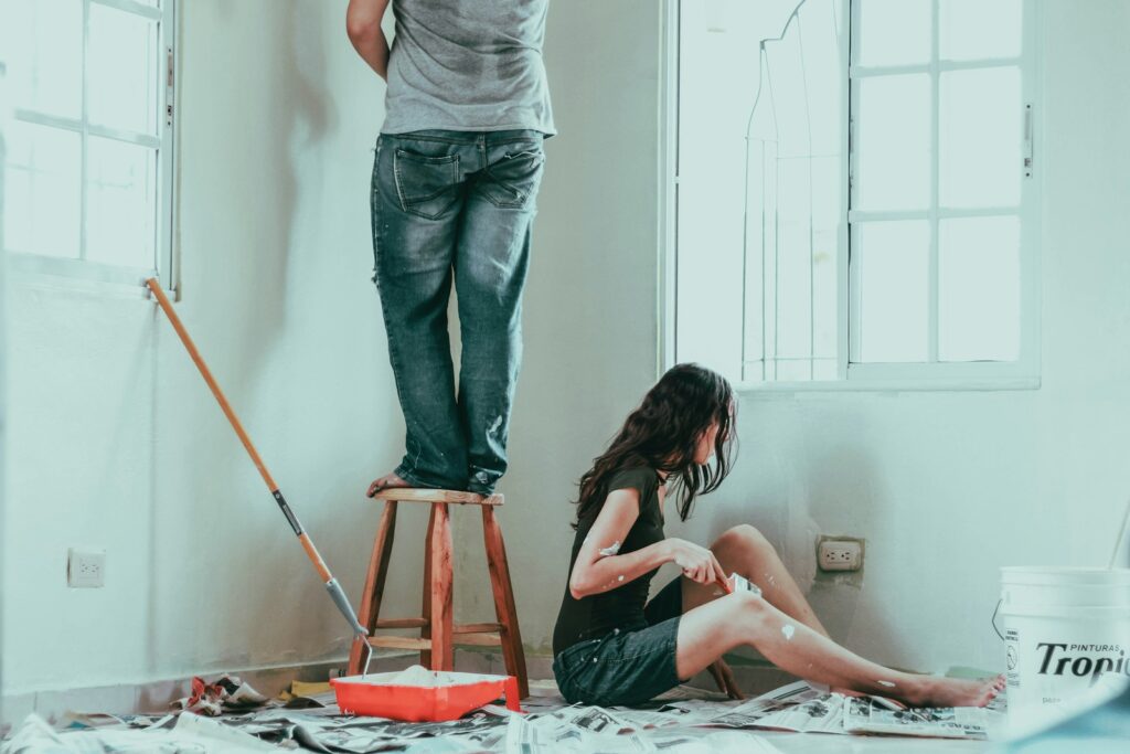 Photo by Roselyn Tirado woman in gray tank top and blue denim jeans sitting on bed