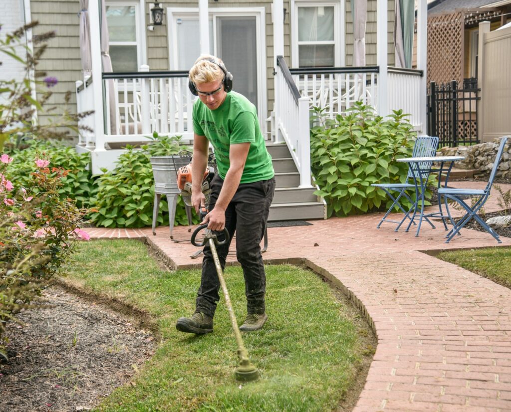 Photo by Jared Muller man in green t-shirt and black pants holding black and brown shovel