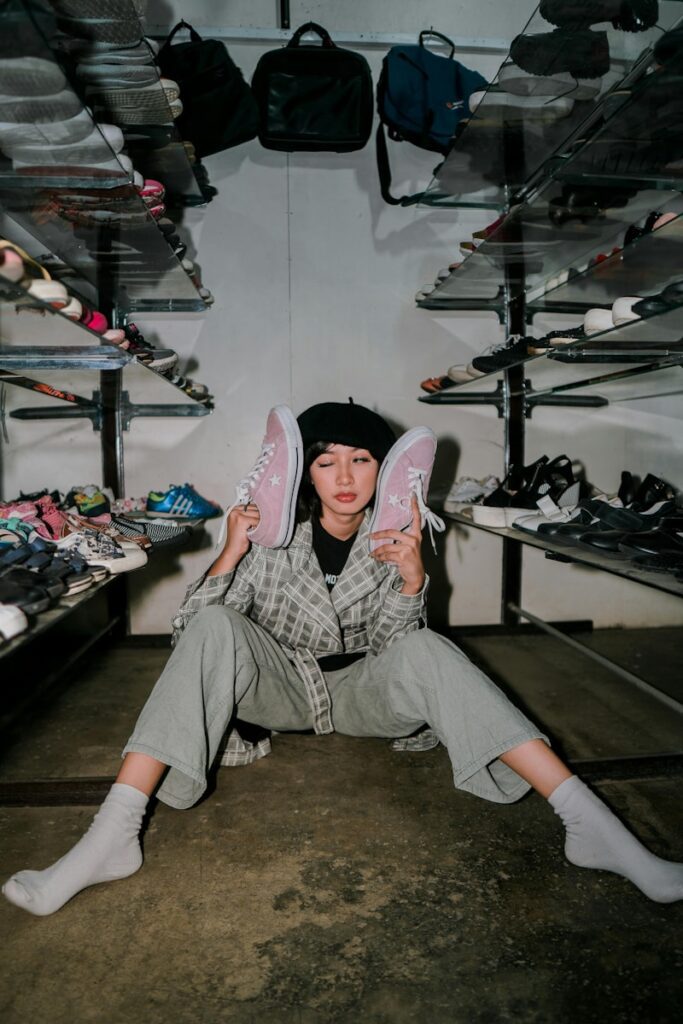 A person sitting on the ground holding a pair of shoes